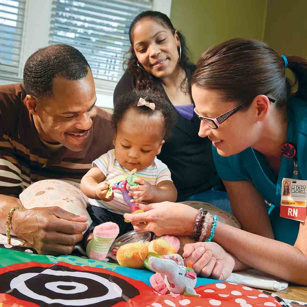 Mark and Adriana Glenn of Flint with 1-year-old Kalayna and nurse Brandi Yousif.